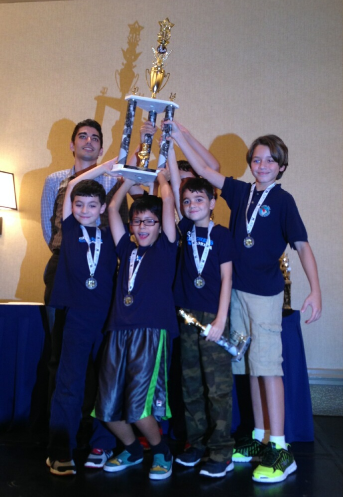 Chess team raising a championship trophy