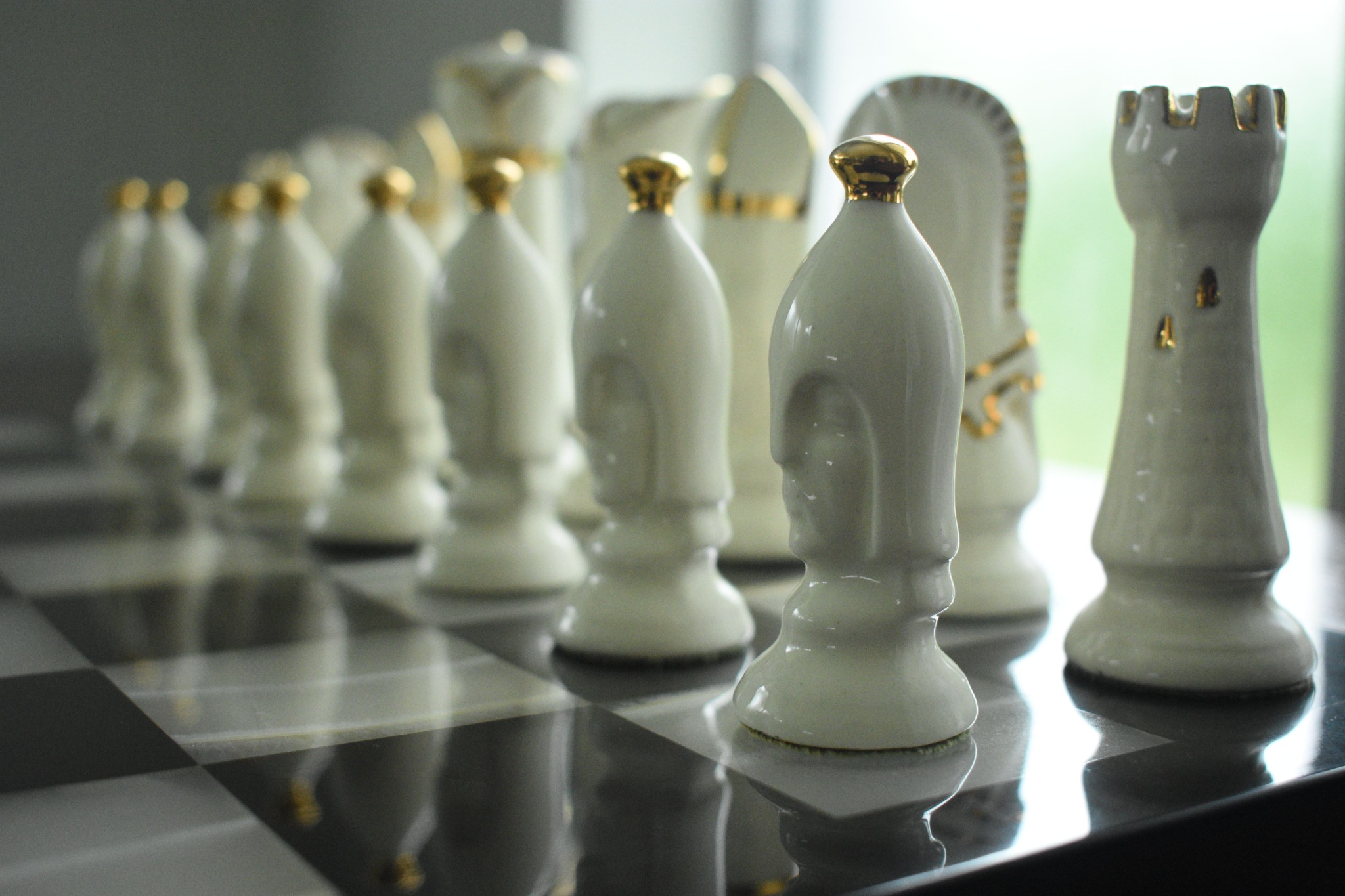 White and gold chess pieces on a chessboard