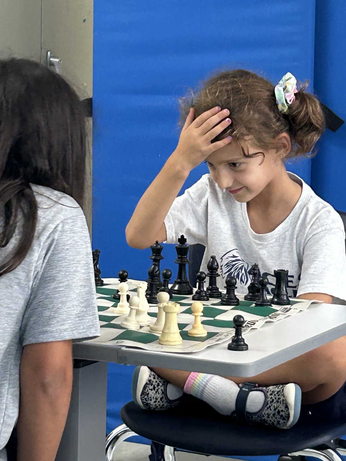 Chess instructor helping students at a school chess table